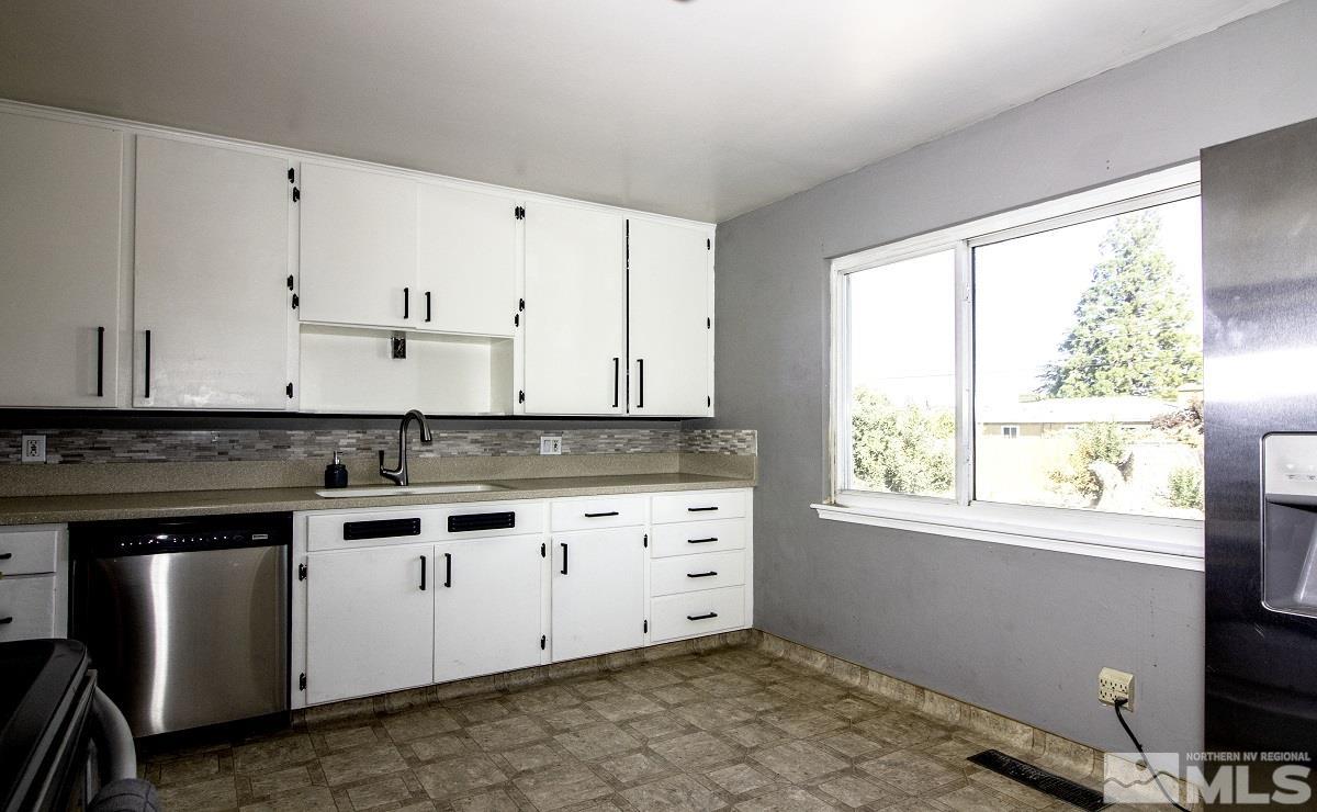 650 Lester Avenue Reno, NV 89502 - Photo 6 of 15 a kitchen with granite countertop white cabinets and white appliances