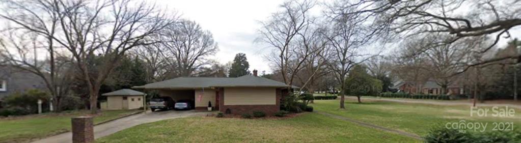 3301 Sharon Road Charlotte, NC 28211 - Photo 2 of 15 a backyard of a house with table and chairs under an umbrella