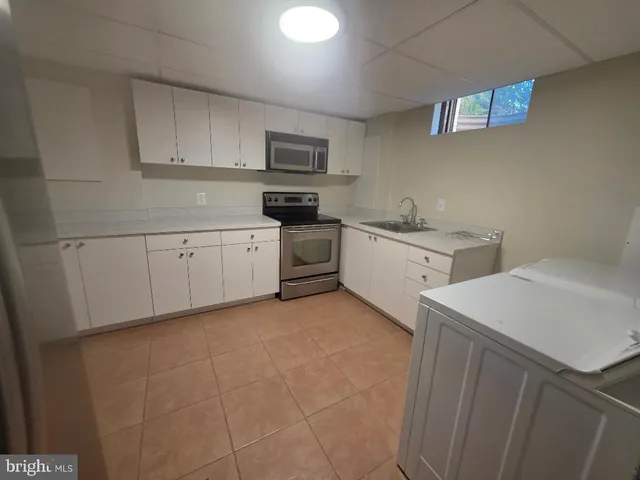 a kitchen with white cabinets and white appliances