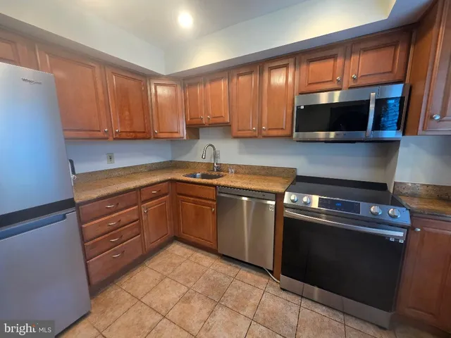 a kitchen with stainless steel appliances granite countertop a stove microwave and sink