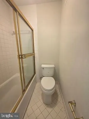 a white toilet sitting next to a shower