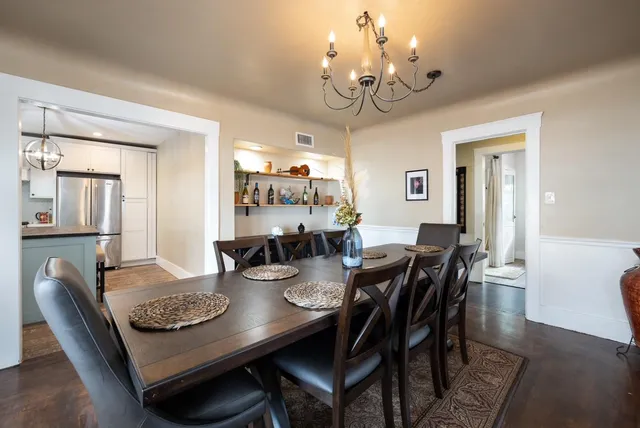 a view of a dining room with furniture a chandelier and wooden floor