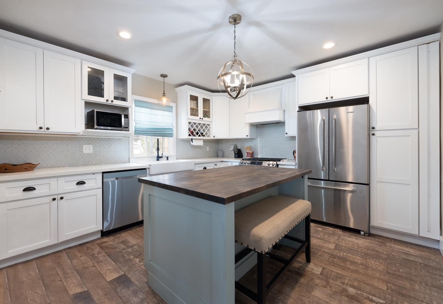 128 Central Avenue Salinas, CA 93901 - Photo 14 of 27 a kitchen with stainless steel appliances granite countertop a refrigerator a sink dishwasher a stove and white cabinets with wooden floor