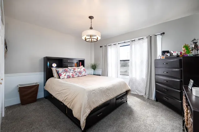 a bedroom with a bed and a chandelier