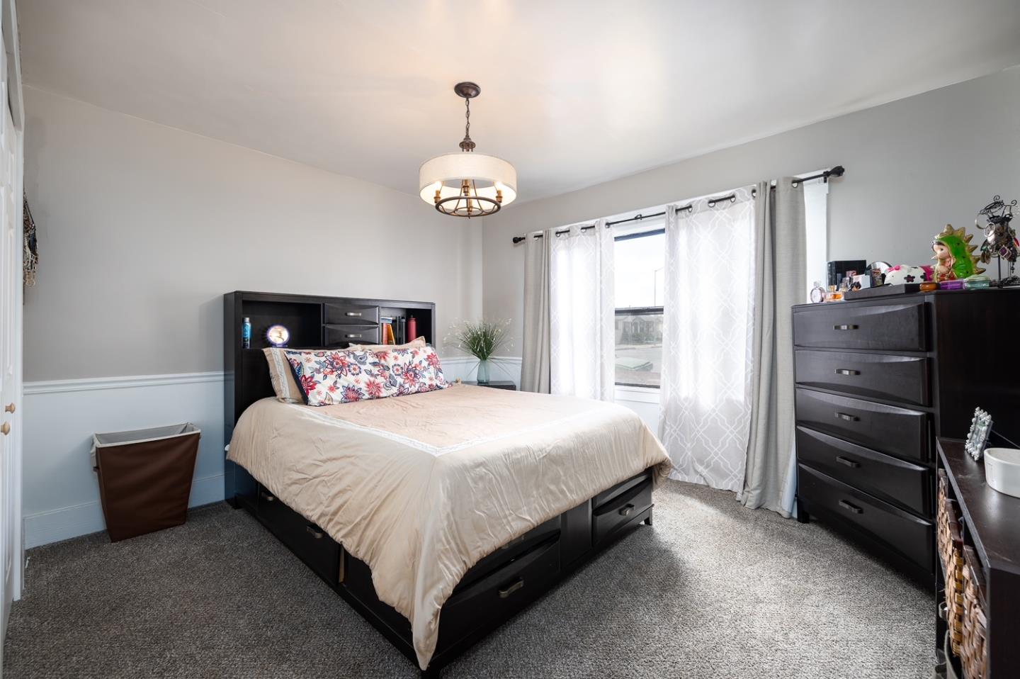 128 Central Avenue Salinas, CA 93901 - Photo 19 of 27 a bedroom with a bed and a chandelier