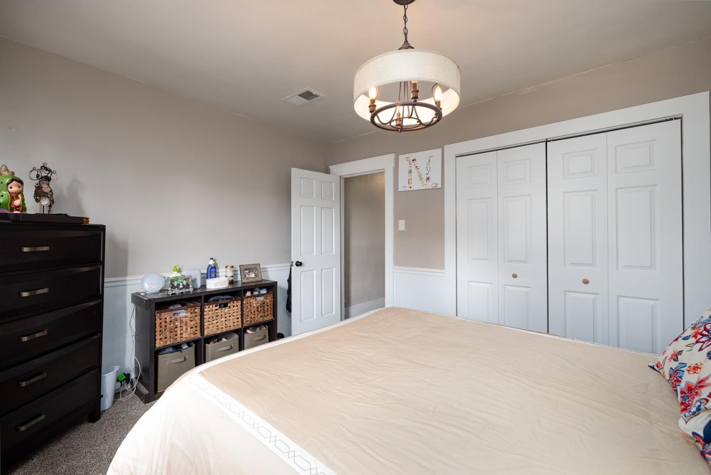 128 Central Avenue Salinas, CA 93901 - Photo 20 of 27 a spacious bedroom with a bed and a chandelier