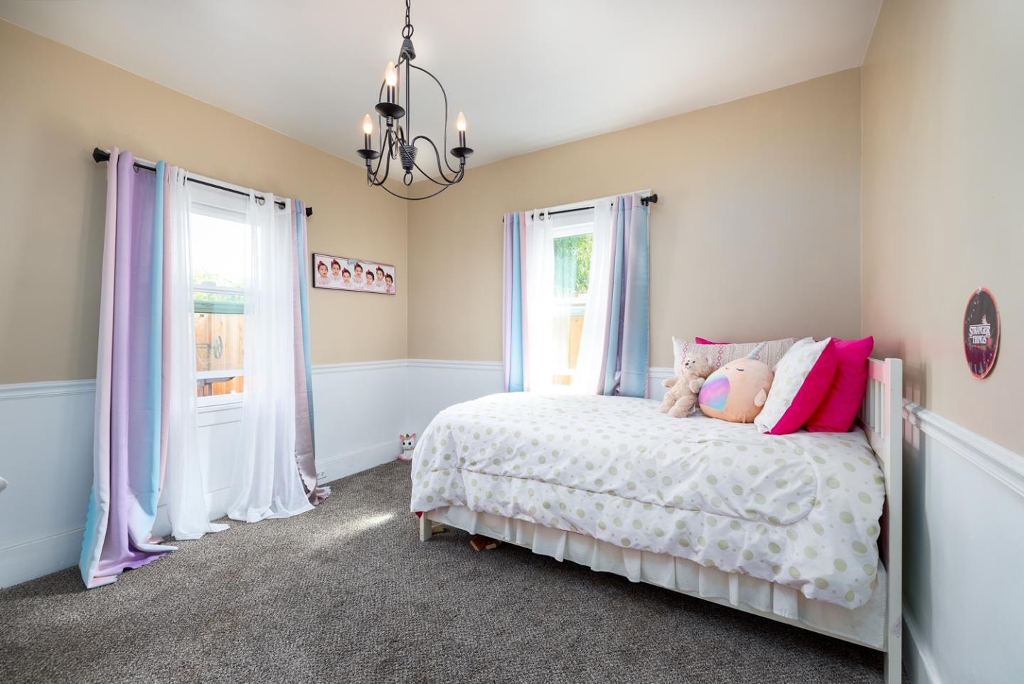 128 Central Avenue Salinas, CA 93901 - Photo 21 of 27 a bedroom with a bed and a chandelier