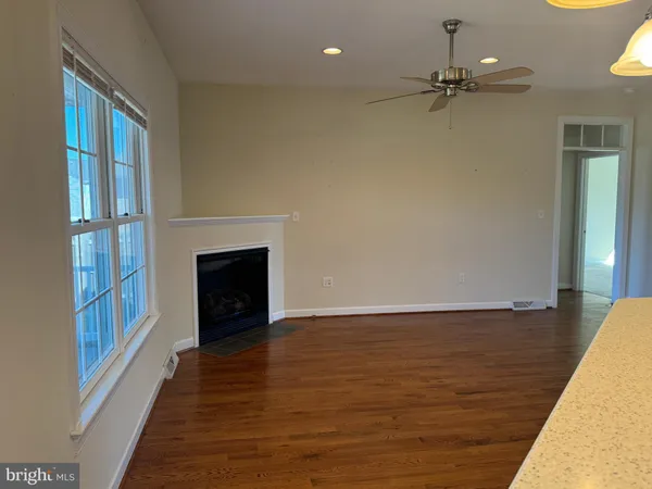 a view of an empty room with a fireplace and a window