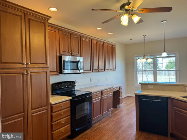 a kitchen with stainless steel appliances granite countertop a refrigerator a stove a sink and a microwave