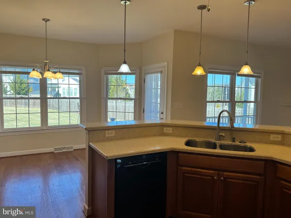 a kitchen with a sink and a wooden floor