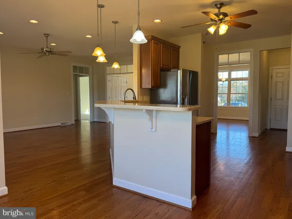 an open kitchen with wooden floor and a large window