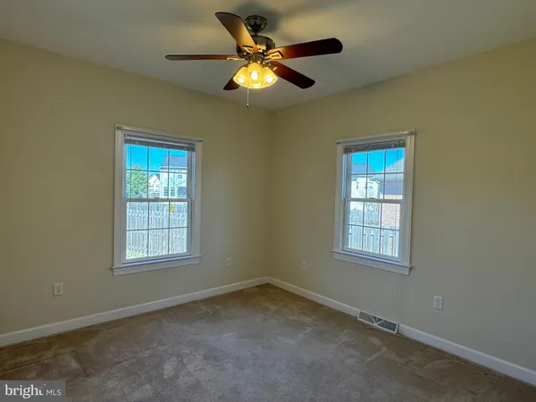 an empty room with window and ceiling fan