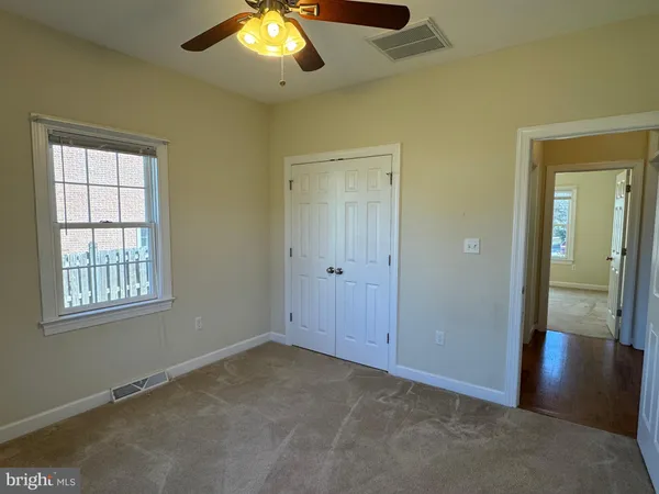 an empty room with closet and wooden floor