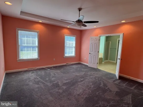a view of empty room with window and ceiling fan