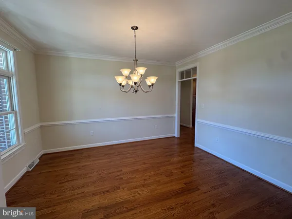 a view of a room with wooden floor and chandelier