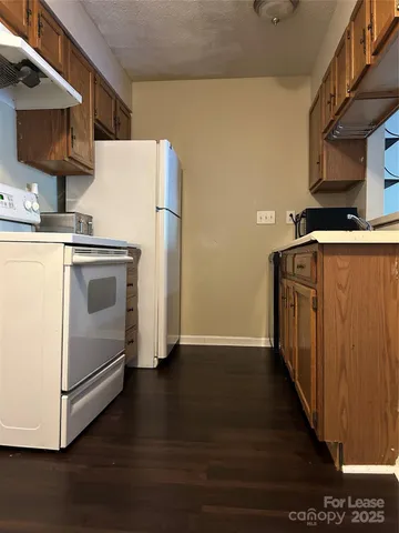 a utility room with wooden floor washer and dryer