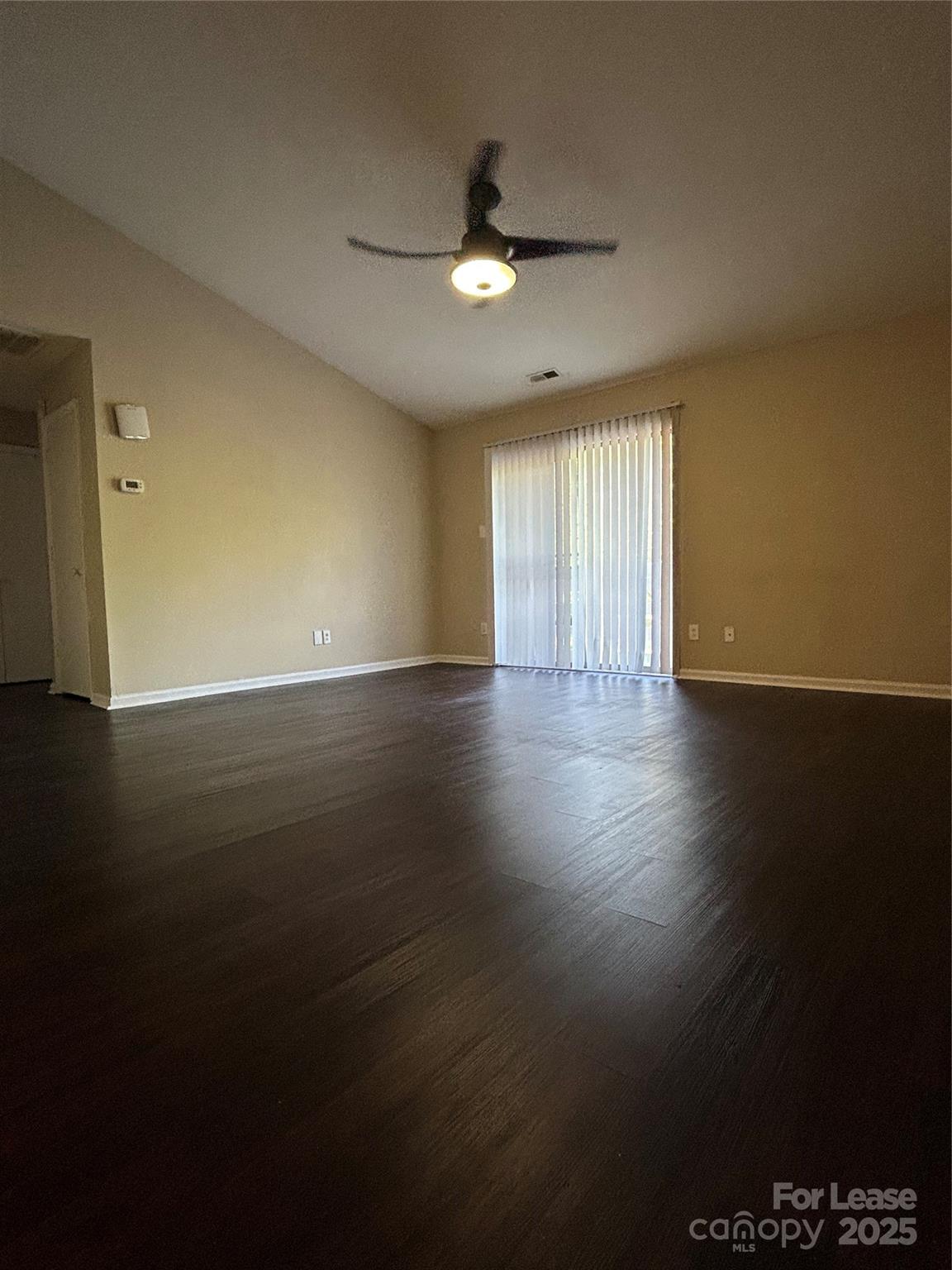 9629 Vinca Circle, Unit H Charlotte, NC 28213 - Photo 4 of 10 an empty room with wooden floor and windows