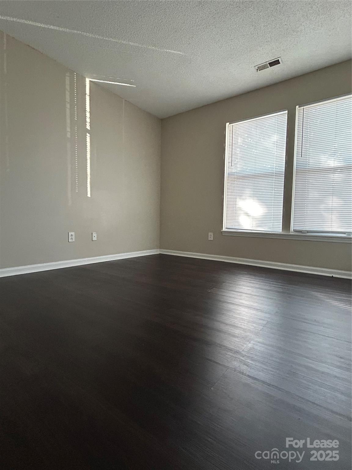 9629 Vinca Circle, Unit H Charlotte, NC 28213 - Photo 7 of 10 an empty room with wooden floor and windows