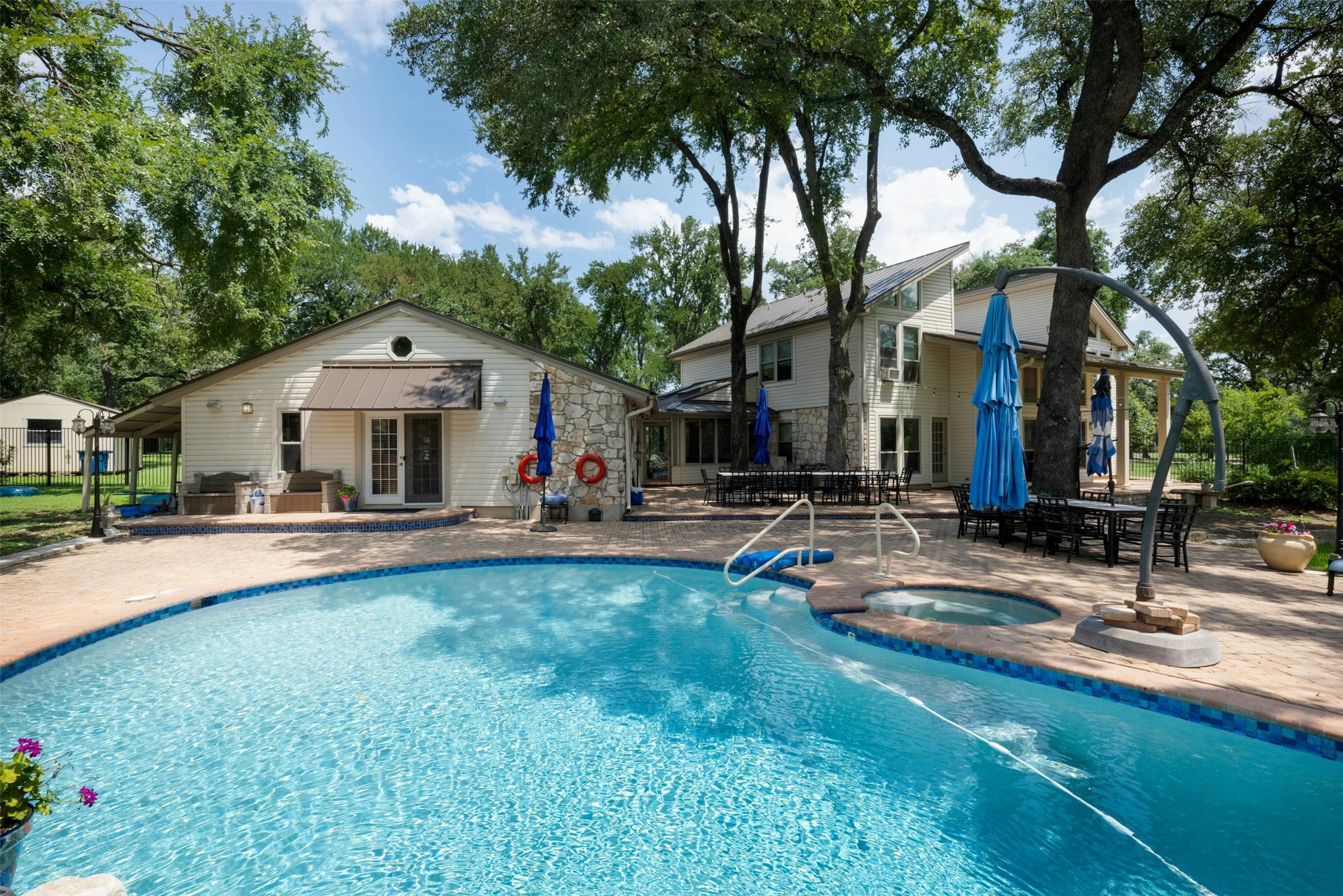 9911 Anderson Mill Road Austin, TX 78750 - Photo 5 of 29 An inviting backyard oasis offers a pristine pool with an integrated spa, surrounded by ample patio space for outdoor entertaining.
