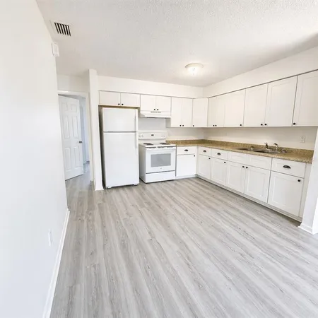 a kitchen with granite countertop white cabinets and white appliances