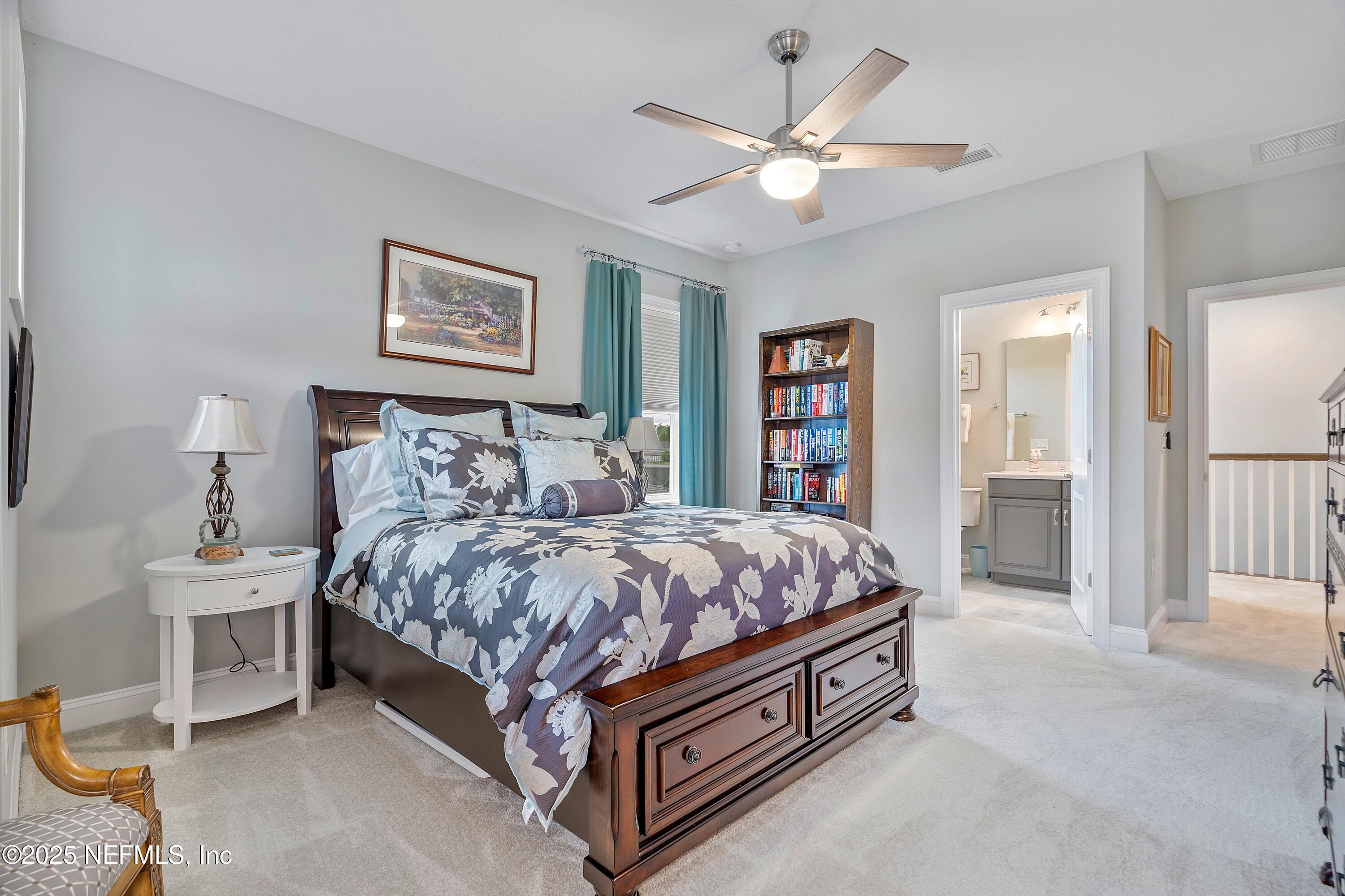 220 Honey Blossom Road St. Johns, FL 32259 - Photo 47 of 99 a spacious bedroom with a bed a lamp and a chandelier