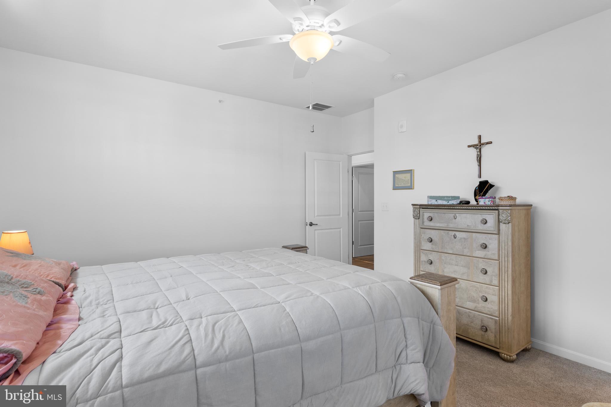 24525 Merlot Drive Lewes, DE 19958 - Photo 28 of 40 a bedroom with a bed and a chandelier
