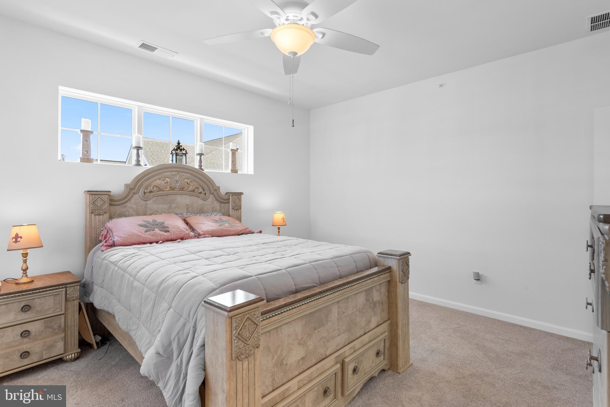 24525 Merlot Drive Lewes, DE 19958 - Photo 29 of 40 a bedroom with a bed and a chandelier