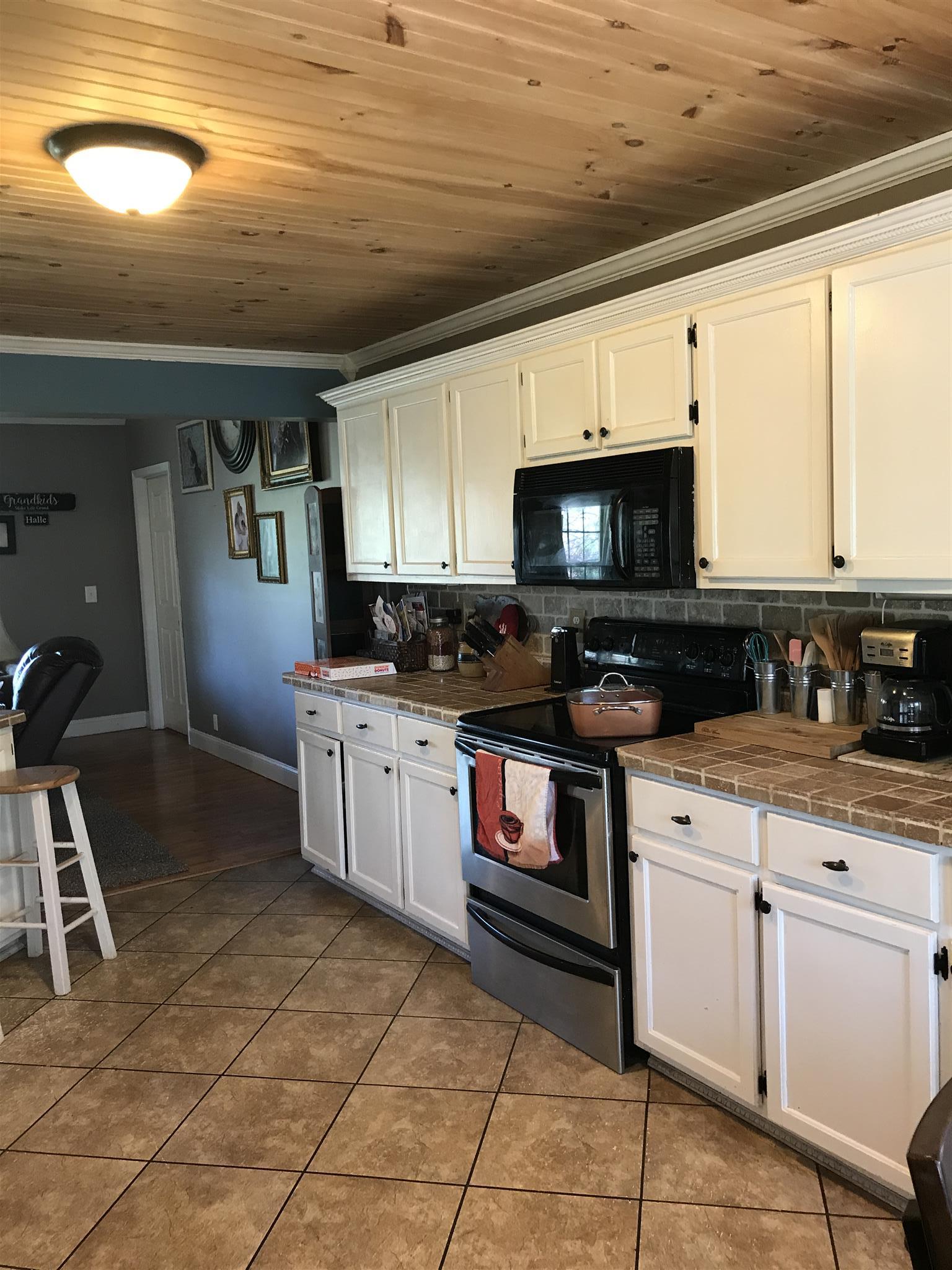 82 Five Points Road Loretto, TN 38469 - Photo 6 of 24 a kitchen with granite countertop a stove a sink and a microwave