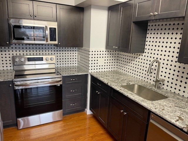 1731 Beacon Street, Unit 512 Brookline, MA 02445 - Photo 12 of 41 a kitchen with a sink and a stove top oven