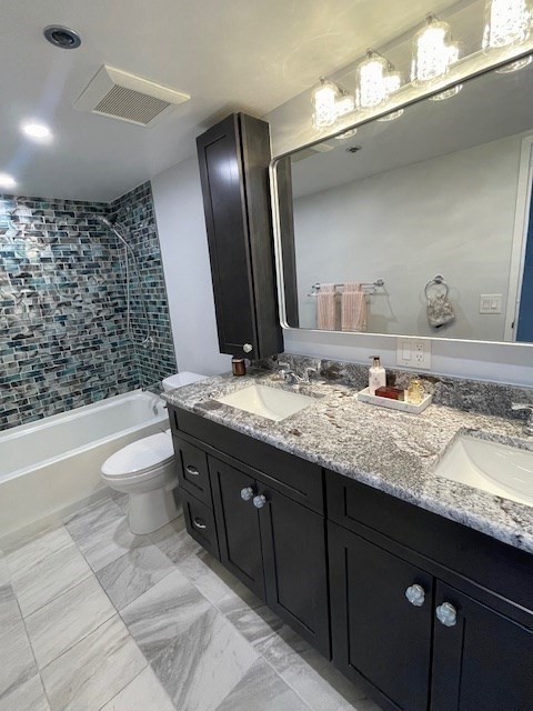 1731 Beacon Street, Unit 512 Brookline, MA 02445 - Photo 14 of 41 a bathroom with a granite countertop toilet a sink and a large mirror