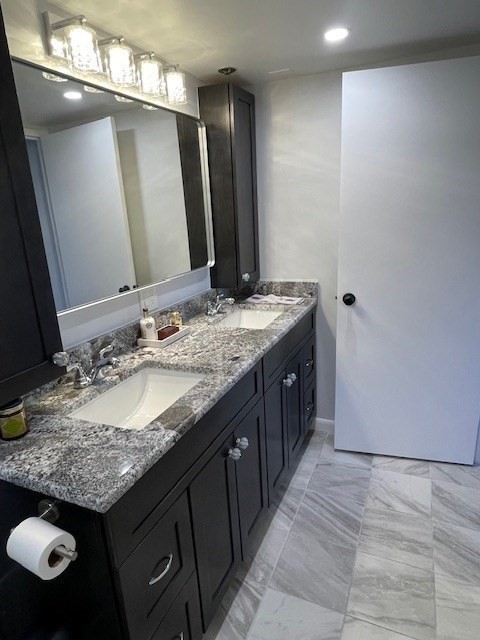 1731 Beacon Street, Unit 512 Brookline, MA 02445 - Photo 16 of 41 a bathroom with a granite countertop sink a large mirror and a shower