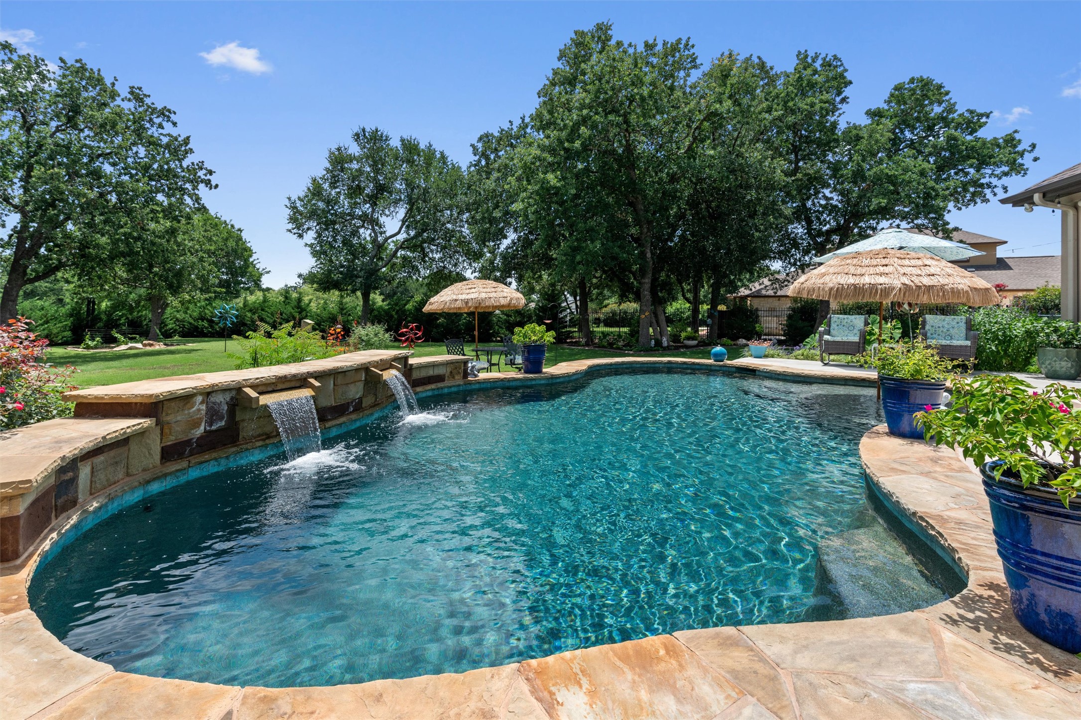 104 Adobe Cove Georgetown, TX 78633 - Photo 1 of 40 An inviting pool featuring cascading waterfalls, stone coping, and lush surrounding landscaping.