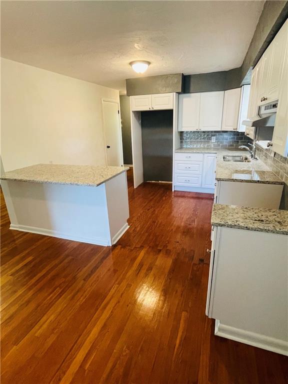 558 Hickory Square Road Connellsville, PA 15425 - Photo 8 of 25 a kitchen with granite countertop white cabinets and wooden floor