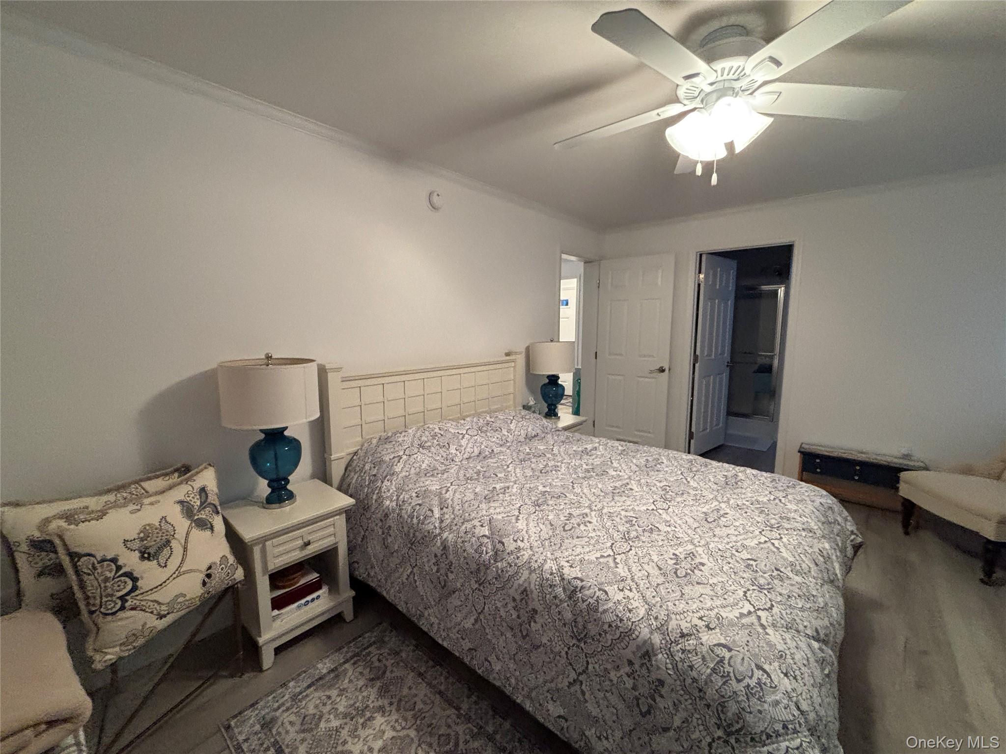 61 Forge Road, Unit 29 Riverhead, NY 11901 - Photo 14 of 38 a bedroom with a bed and a chandelier