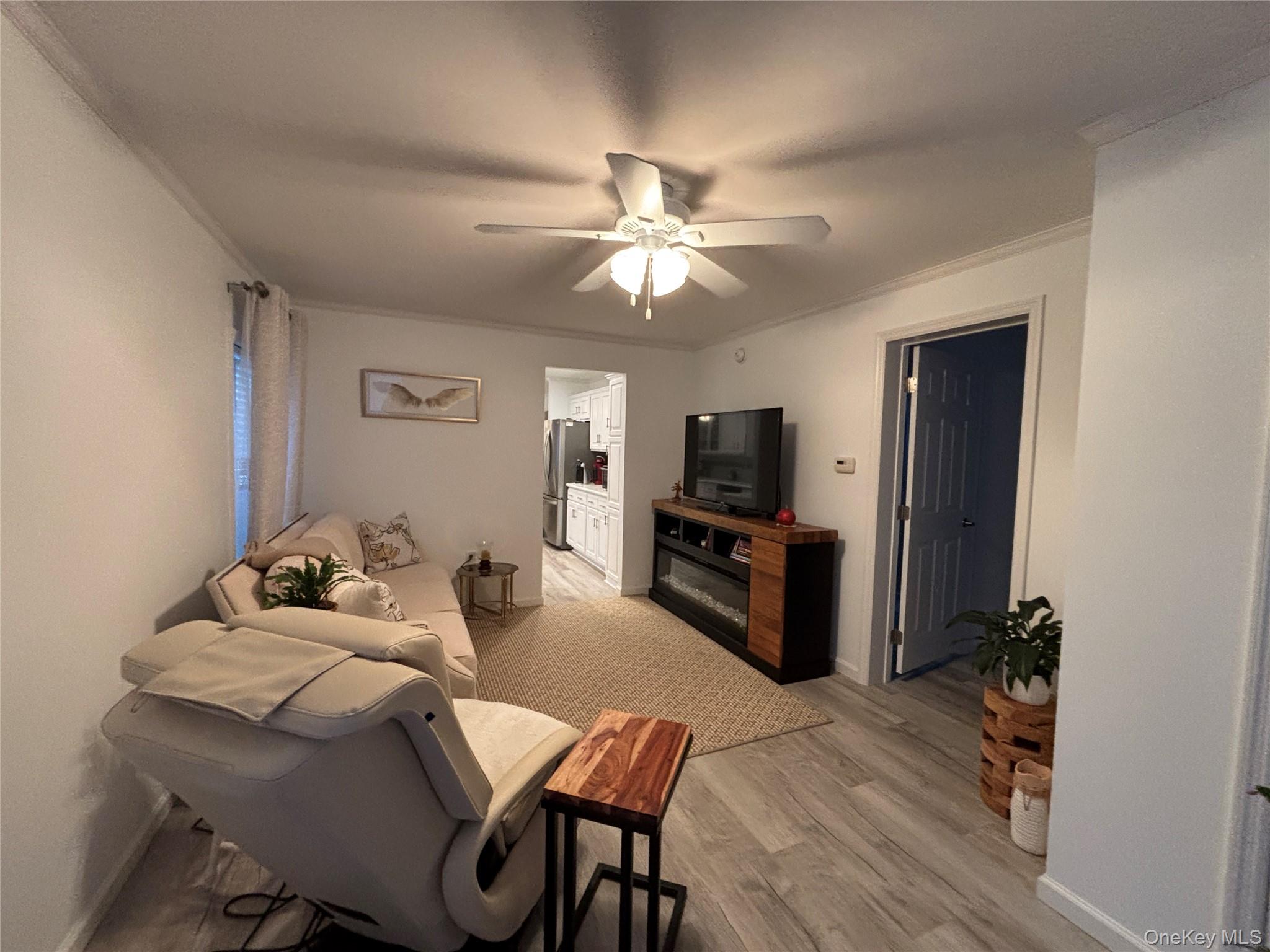 61 Forge Road, Unit 29 Riverhead, NY 11901 - Photo 18 of 38 a living room with furniture a flat screen tv and a window