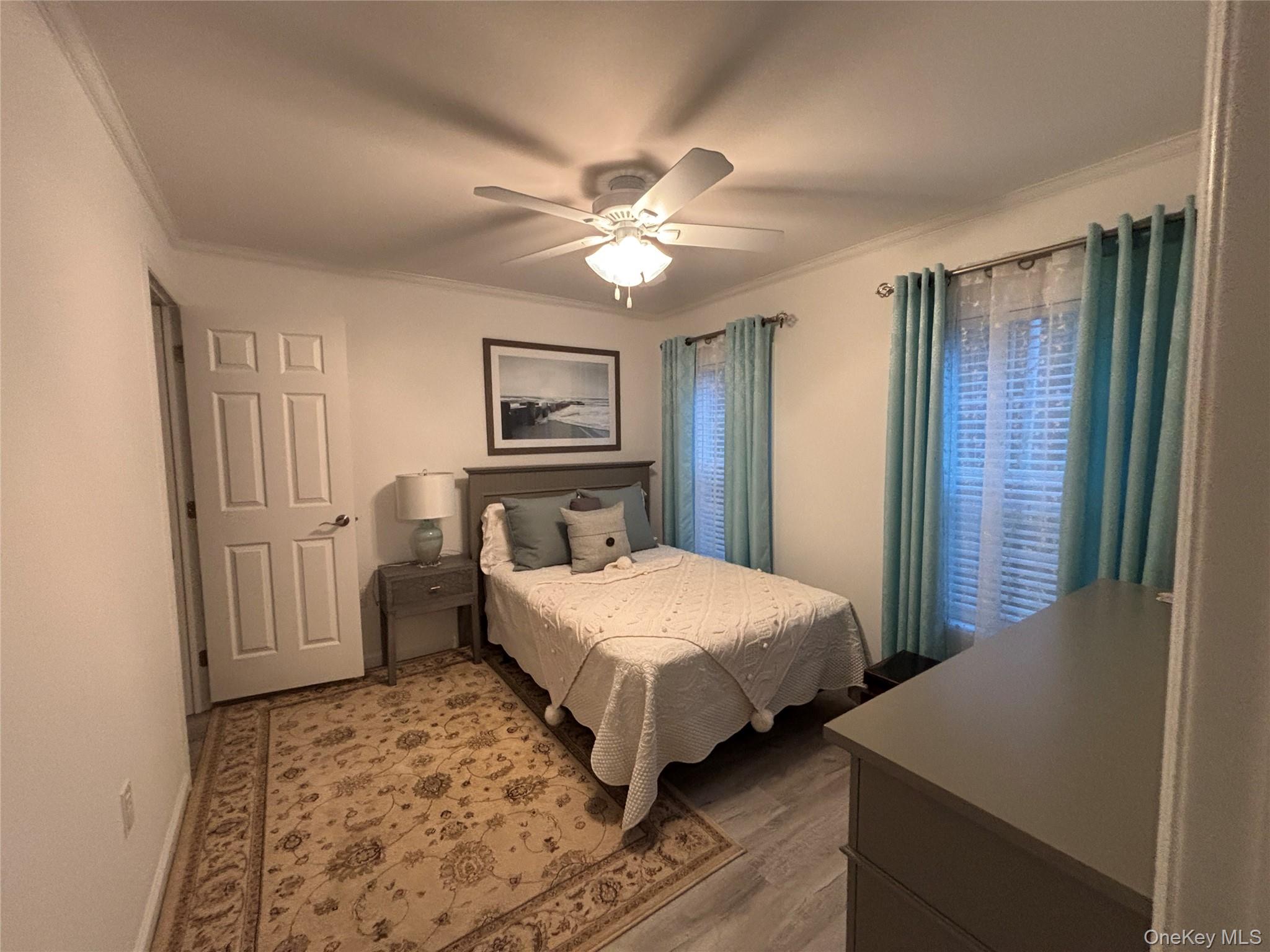 61 Forge Road, Unit 29 Riverhead, NY 11901 - Photo 19 of 38 a bedroom with a bed and a chandelier