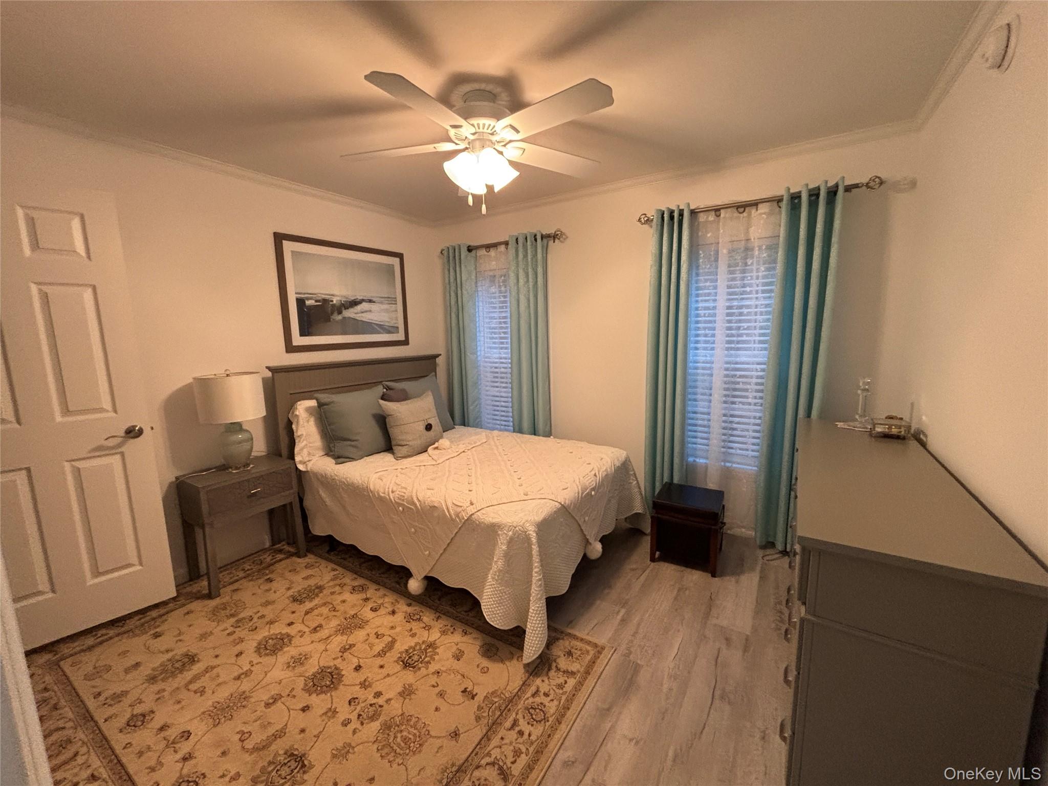 61 Forge Road, Unit 29 Riverhead, NY 11901 - Photo 20 of 38 a spacious bedroom with a bed and a chandelier