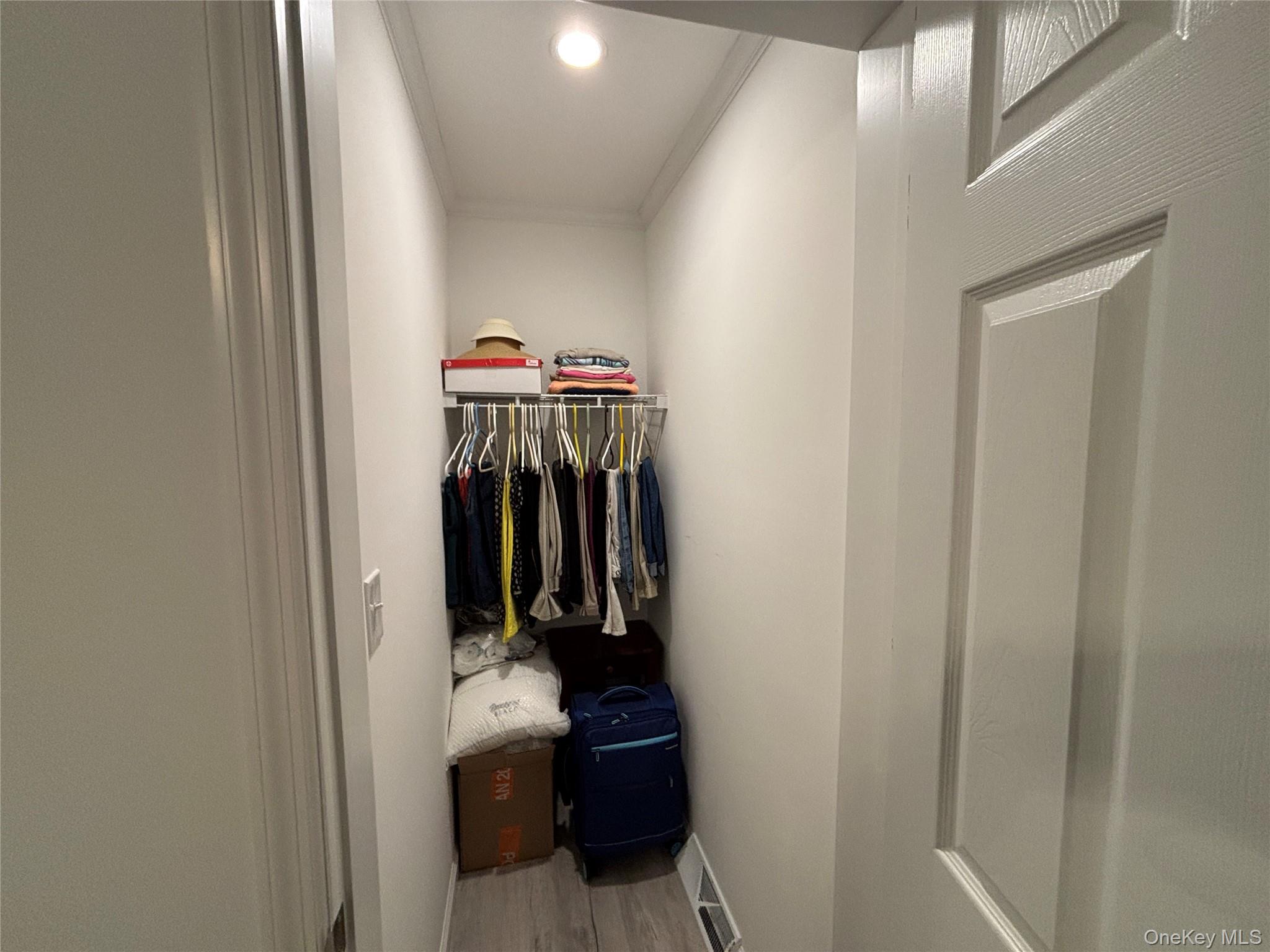 61 Forge Road, Unit 29 Riverhead, NY 11901 - Photo 22 of 38 a view of walk in closet with clothes and shoes