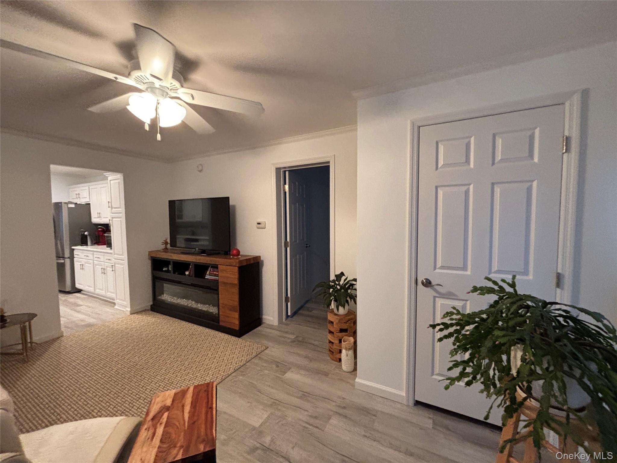 61 Forge Road, Unit 29 Riverhead, NY 11901 - Photo 25 of 38 a living room with furniture and a flat screen tv