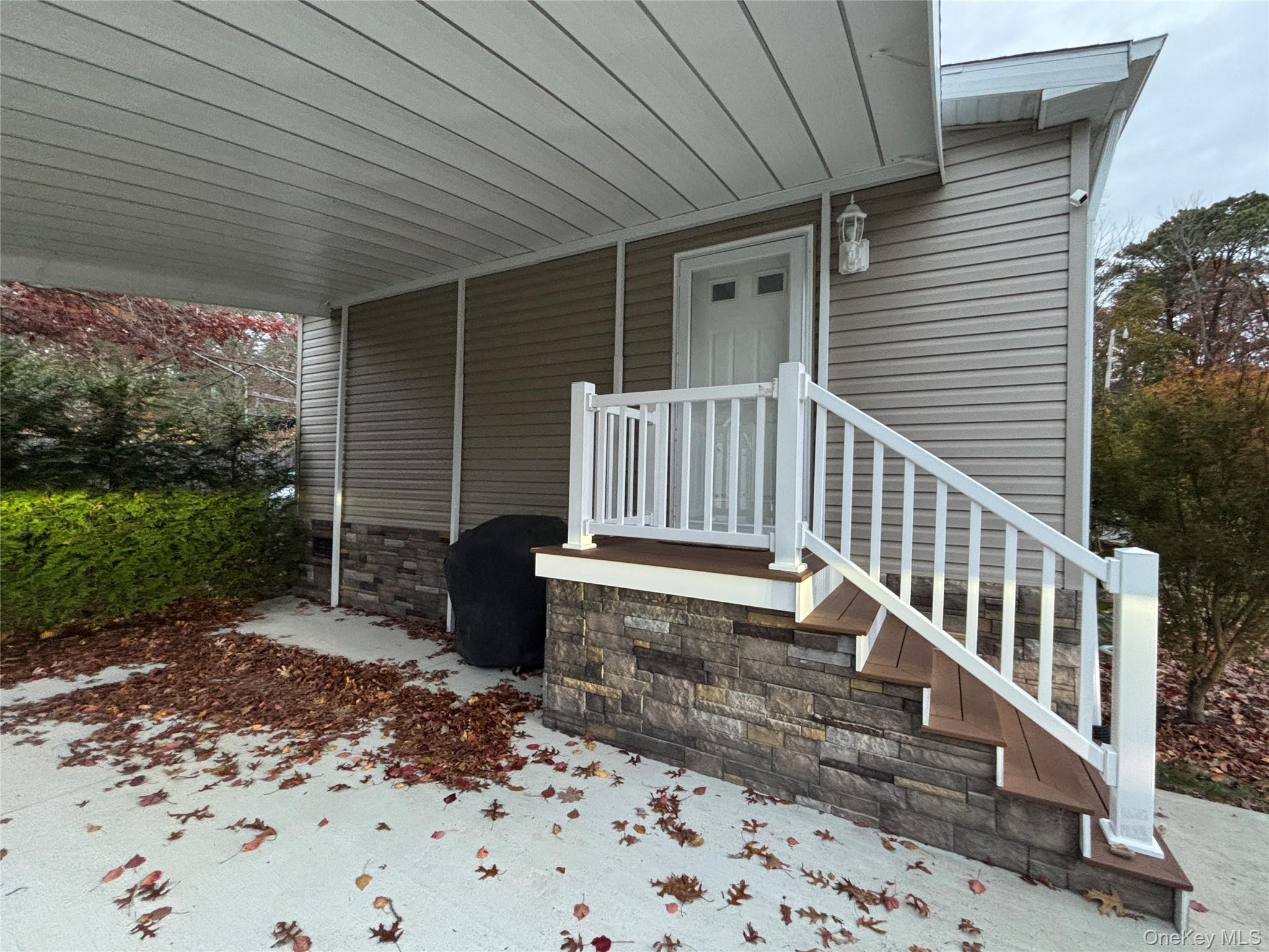 61 Forge Road, Unit 29 Riverhead, NY 11901 - Photo 27 of 38 a view of a patio with a table and chair