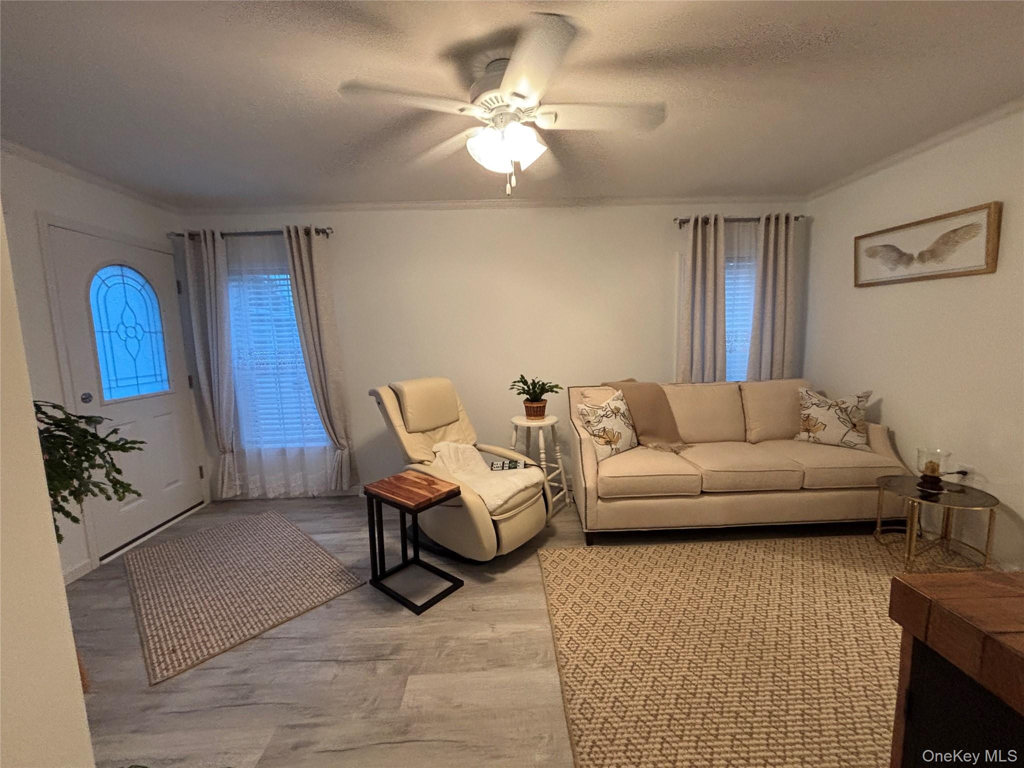 61 Forge Road, Unit 29 Riverhead, NY 11901 - Photo 3 of 38 a living room with furniture and a flat screen tv