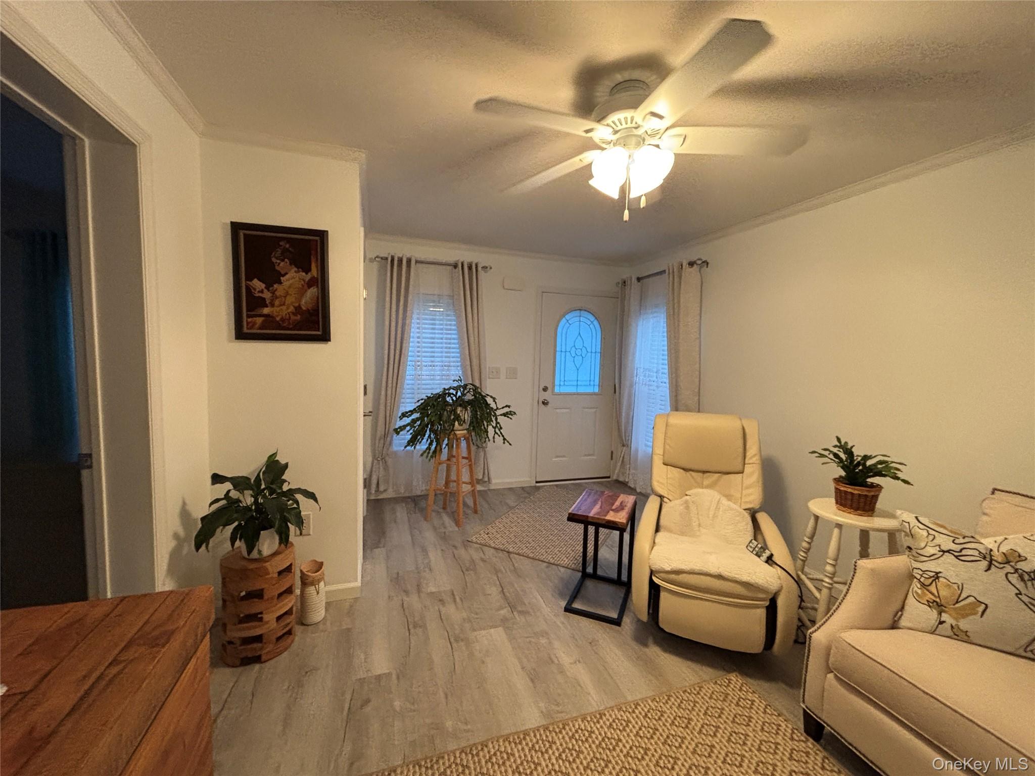 61 Forge Road, Unit 29 Riverhead, NY 11901 - Photo 4 of 38 a living room with furniture and a chandelier