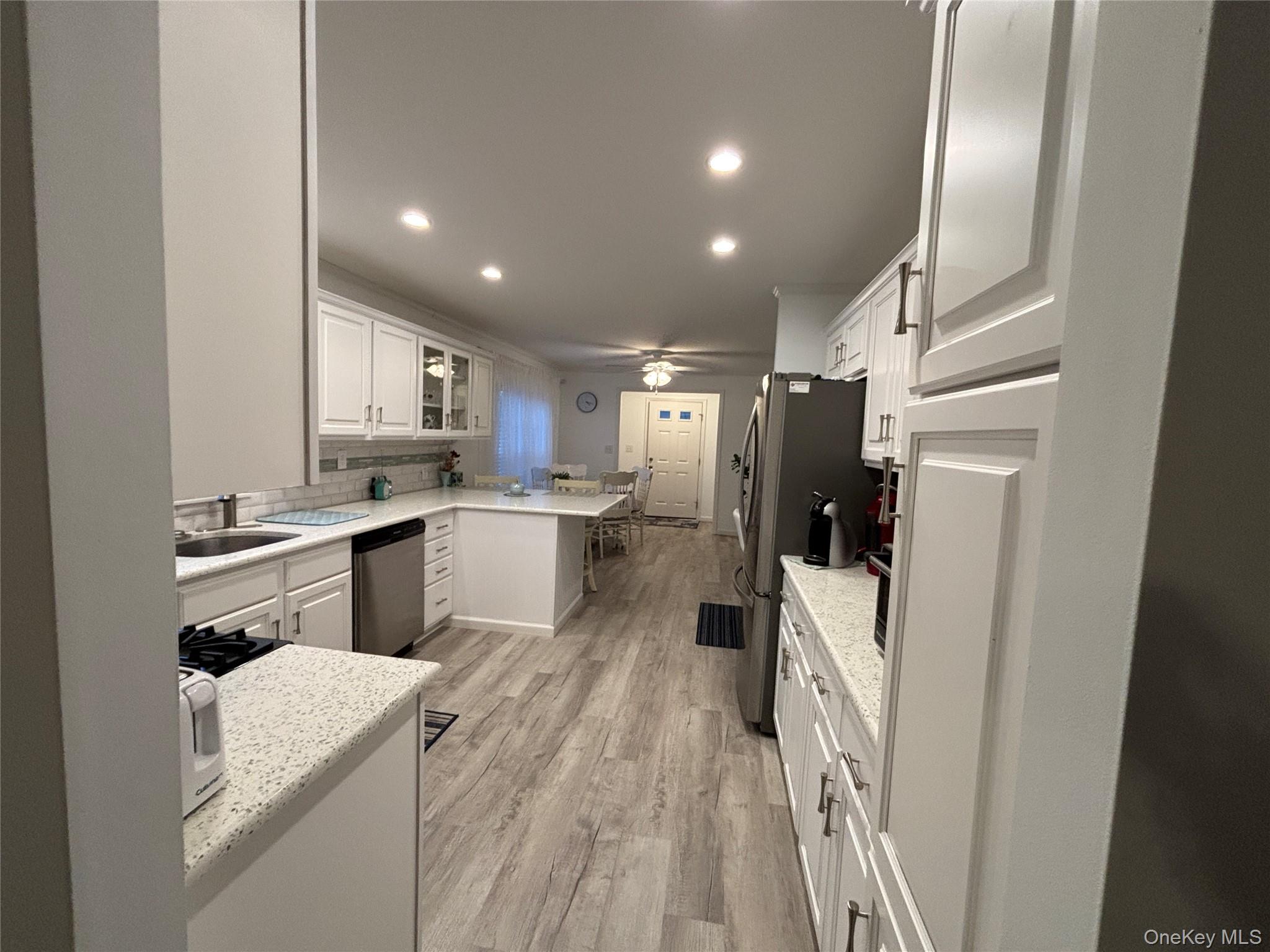 61 Forge Road, Unit 29 Riverhead, NY 11901 - Photo 6 of 38 a kitchen with a refrigerator a sink and cabinets