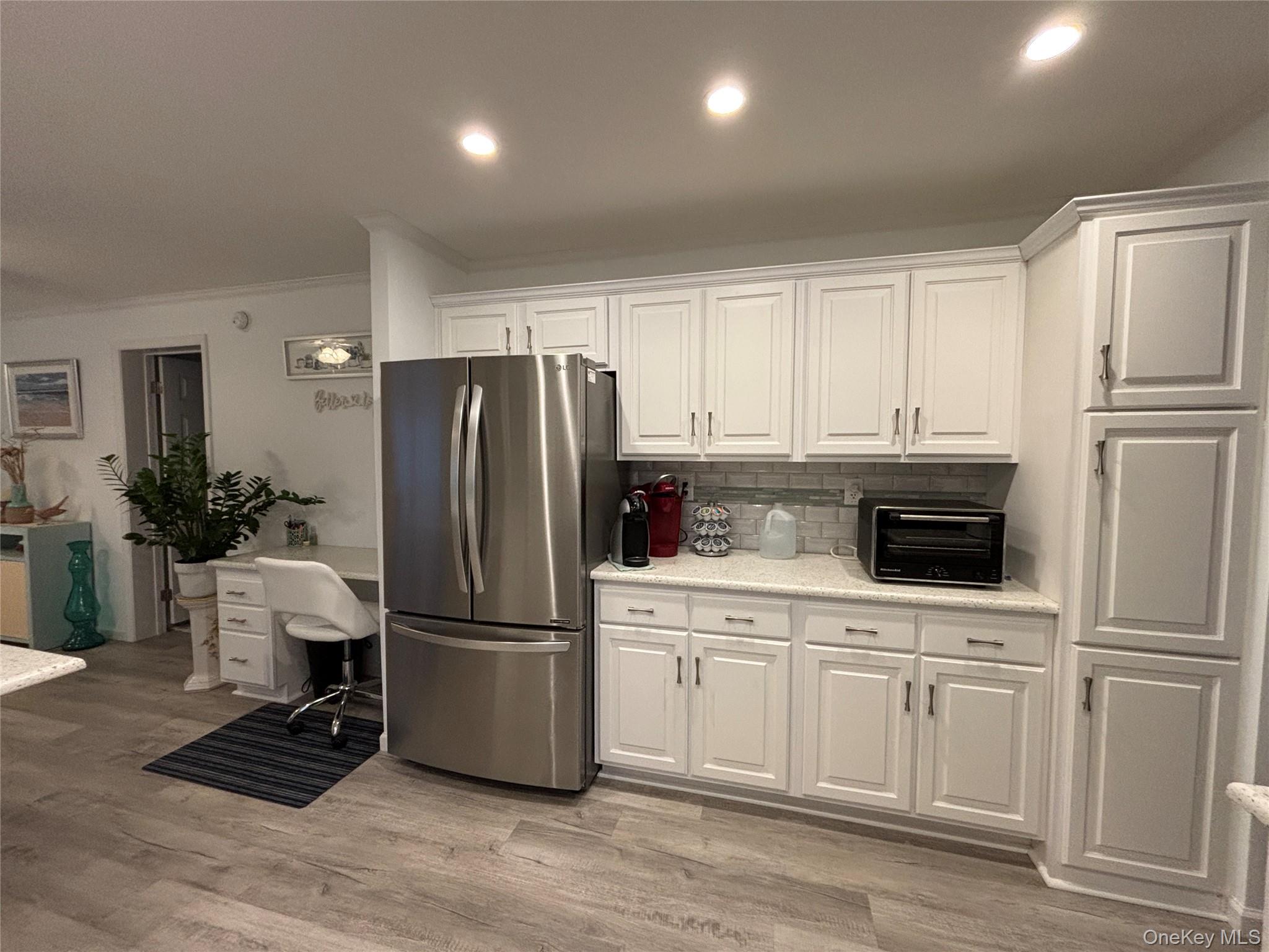 61 Forge Road, Unit 29 Riverhead, NY 11901 - Photo 8 of 38 a kitchen with a refrigerator sink and cabinets
