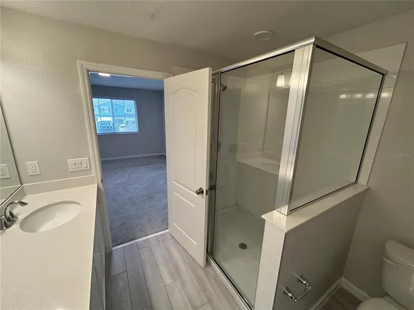a bathroom with a sink and glass door shower