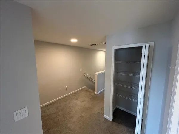 an empty room with a wooden door and a sink