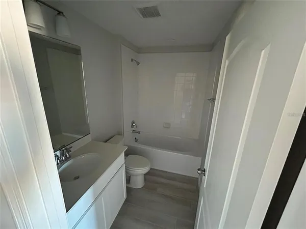 a bathroom with a sink a toilet a tub and shower