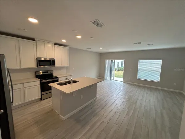 a kitchen with a refrigerator and a stove top oven