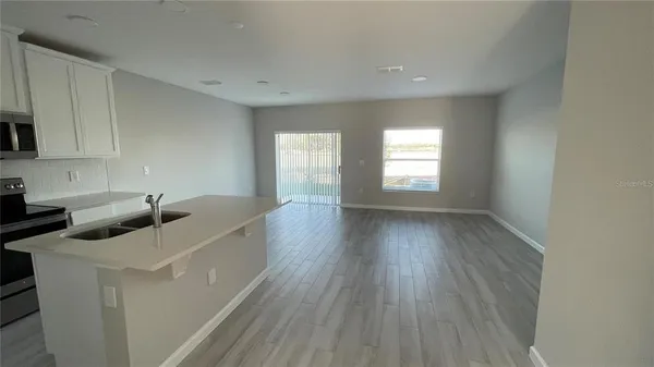 a kitchen with sink a refrigerator and window