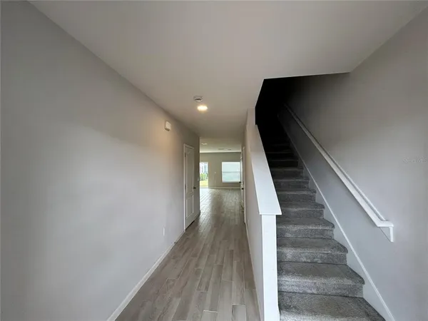 a view of entryway and hall with wooden floor